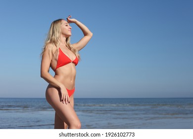 Beauty Woman In Red Swimsuit On The Beach