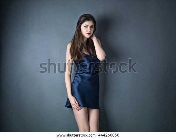 Beauty woman in a\
silk slip on gray\
background
