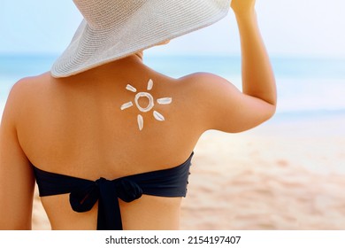 Beauty Woman with sun shaped sunscreen on her back. Skin care. Sun protection. Sun cream.