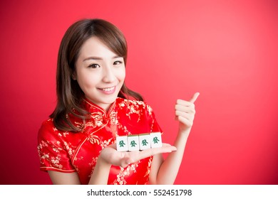 beauty woman thumb up and show mahjong to you in chinese new year - Rich and wealthy text on girl hand in Chinese words