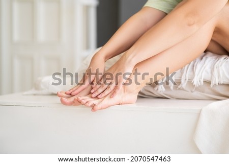 Beauty women's legs with smooth skin in the home interior, foot care and depilation concept, unrecognizable person