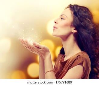 Beauty Young Woman Blowing Magic Dust With Stars From Her Hands. Holiday Concept. Beautiful Girl. Miracle.