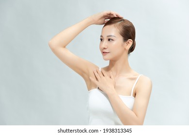 Beauty, youth, freshness and perfect skin. Armpit epilation, laser hair removal. Beautiful woman holding her arms up and showing clean underarms, depilation smooth clear skin in studio.