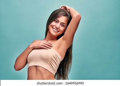 Beauty, youth, freshness and perfect skin.Armpit epilation, laser hair removal. Beautiful woman with long hair holding her arms up and showing clean underarms, depilation smooth clear skin in studio.