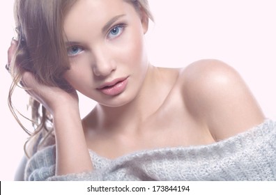 Beauty.Female  portrait on the white background. Close-up. Space. Natural make-up.The young girl sitting, touching a hand to the face.Space. Shoulder.beautiful brows.Nude makeup.Full lips.Foundation