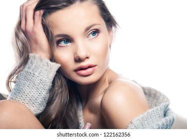 Beauty.Female pretty portrait on the white background. Close-up. Space. Natural make-up.The young girl sitting, touching a hand to the face and looks away.Space. Shoulder.beautiful brows.Nude makeup