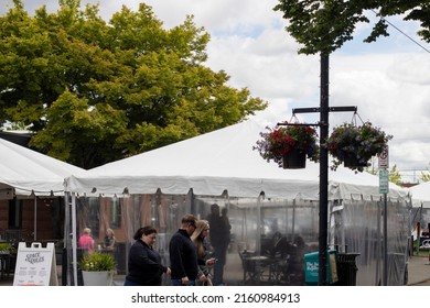 Beaverton, OR, USA - May 25, 2022: A father carrying a baby is seen waiting inside an outdoor dining tent in Beaverton, Oregon.