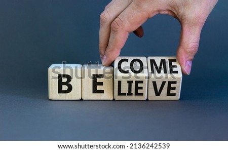 Become or believe symbol. Businessman turns wooden cubes and changes the concept word Believe to Become. Beautiful grey table grey background. Business become or believe concept. Copy space.