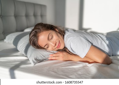 Bed Asian girl happy smiling sleeping on stomach sleeper resting head on foam pillow. Healthy sleep. - Powered by Shutterstock