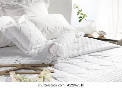 bed closeup , classy white covers , in sunny white bedroom 