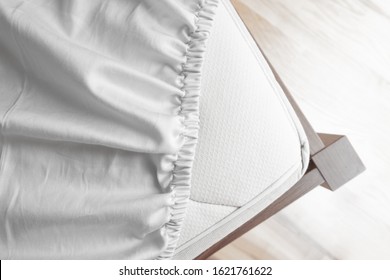 Bed corner with white fitted sheet. White sheet with elastic band. Bed cover. - Shutterstock ID 1621761622