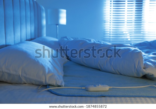 Bed with\
electric heating pad indoors at\
night