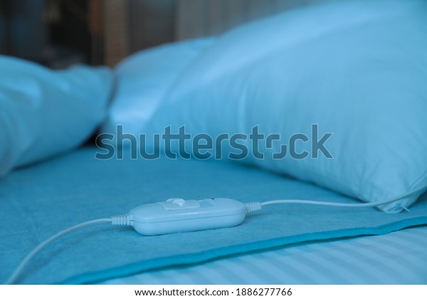 Bed with\
electric heating pad indoors at\
night