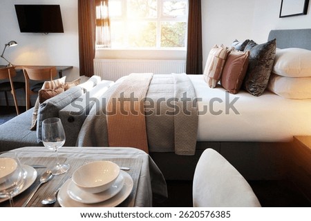 Bed, empty room and hotel accommodation or service dinner meal with interior design, holiday or home decor. Furniture, plates and lodge resort in London or property linen, apartment or residential