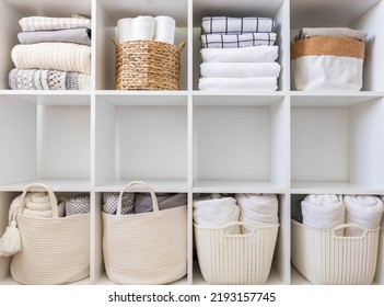 Bed linens closet neatly arrangement on shelves with copy space domestic textile Nordic minimalism comfortable storage. Rolled towels in straw basket duvet cover sheet pillow plaid in cupboard