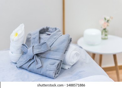 A Bed Of Neatly Stacked Bathrobes And Aromatherapy Machine On A Small Coffee Table