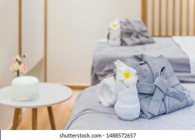 A Bed Of Neatly Stacked Bathrobes And Aromatherapy Machine On A Small Coffee Table