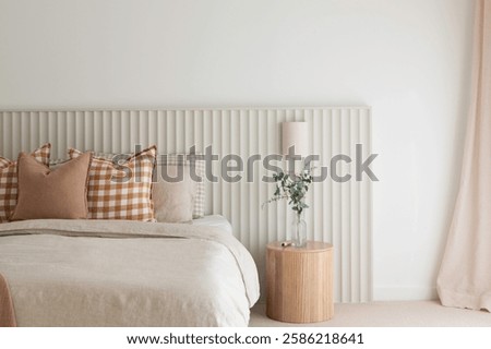 Bed with pattern pillows and modern headboard. A close up picture of a beautiful well interior design luxurious bedroom. Filled with natural light.