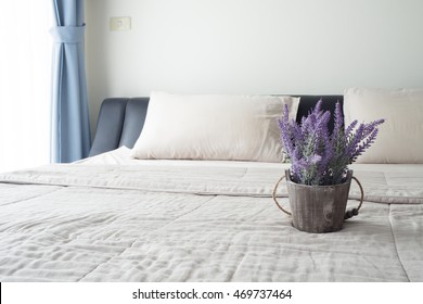 The Bed With Purple Lavender Flower On Flower Pot And Sunlight From Glass Of Windows  In Bedroom.