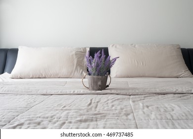 The Bed With Purple Lavender Flower On Flower Pot And Sunlight From Glass Of Windows  In Bedroom.