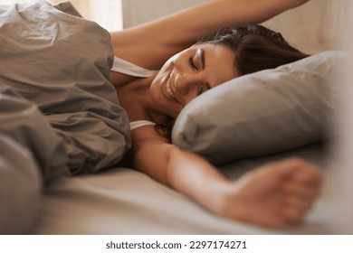 Bed, stretching and happy woman waking up in the morning after sleep, rest and relax in her home. Resting, smile and female stretch in her bedroom, content and peaceful, cheerful and comfortable - Shutterstock ID 2297174271
