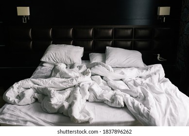 Bed with white linens. Crumpled sheets and pillows after a night's sleep