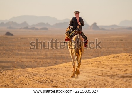 A Bedouin man riding a camel in wadi rum desert