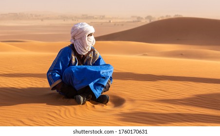 Bedouin sitting on the sand in the Sahara desert