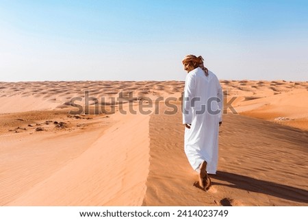 Bedouin walking in the desert- wahiba sands- oman