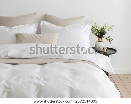 Bedroom with a double bed, fluffy down comforter with a duvet cover, four pillows, one beige cushion and bedside table with vase. Close-up front view vertical photo. Suitable for mockup