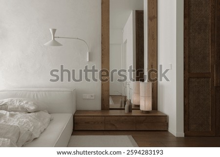 The bedroom features a solid oak bedside table, rattan closet, tall mirror. Soft linen bed linens drape the bed, while clay wall decor adds earthy elegance, creating a tranquil, imperfect sanctuary. 
