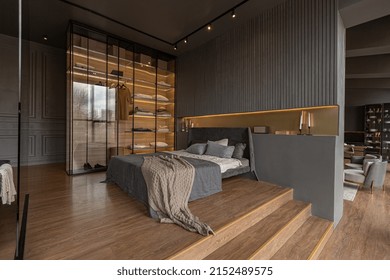 bedroom and freestanding bath behind a glass partition in a chic expensive interior of a luxury home with a dark modern design with wood trim and led light - Shutterstock ID 2152489575