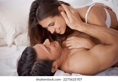 Bedroom, happiness and bed with a couple feeling love, care and relax in the morning. Intimate, marriage and happy woman and man together at home ready for sex and relationship intimacy at a house
