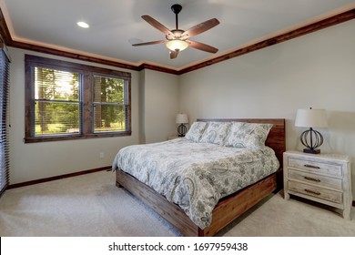 Bedroom Interior With Beige Walls And Wood Trim And Ceiling Fan.