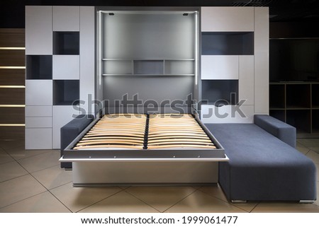Bedroom interior flat with Vertical Murphy Wall Bed, roll-away pull out bed stored into wardrobe with lots of shelves and drawers, minimalist interior design, modern architecture concept.