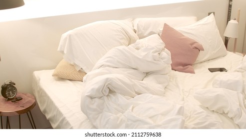 Bedroom Interior In The Morning. A Bed With Blankets And Pillows Without Anyone. No People. The Phone Is On The Sheet.