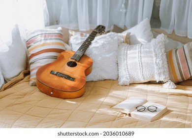 Bedroom interior, room inside of motor home. Bed furniture with different pillows decor, modern design of comfortable space in camper van. Wooden guitar at blanket, tray with cups. - Powered by Shutterstock