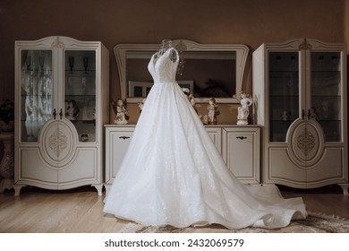 Bedroom interior with wedding dress prepared for the ceremony. A beautiful lush wedding dress on a mannequin in a hotel room.