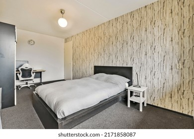 Bedroom with a large bed and a workplace with a computer in a modern house