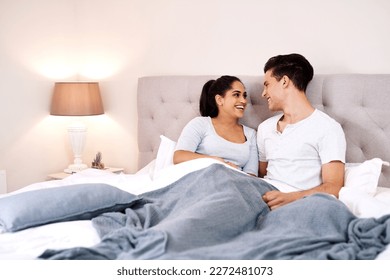 Bedroom, love and interracial couple laughing together in home holding hands at night. Smiling, diversity and marriage of an Indian woman and man with care and relax happiness with a smile in a house - Powered by Shutterstock