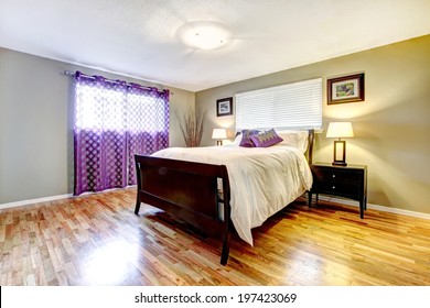 Bedroom With Shiny Hardwood Floor, Dark Brown Furniture Set And Purple Curtain