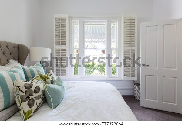 Bedroom window with a garden view in a luxury\
country house bedroom