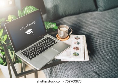 Bedroom,workplace Without People,close-up Of Laptop With An Inscription- E-learning On Screen On Glasses Table, Desktop.Nearby Is Newspaper, Cup Of Coffee. Nobody. Online Education, Distance Learning.