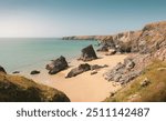 Bedruthan Steps, Cornwall - Scenic coastal landscape with dramatic cliffs, golden sandy beach, and rocky formations against a clear blue sky, rugged natural beauty , British coastline in summer