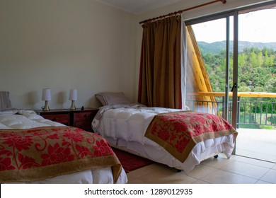 Beds In A Hotel Room. White Feather Blankets. Red Curtains. Two Beds. One Double Bed. View From The Window To The Mountains