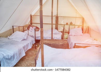 Beds Under A Large Tent Retro Field Hospital. Military Field Medicine In The 18th Or 19th Century. Portable Hospital For Wounded Soldiers.