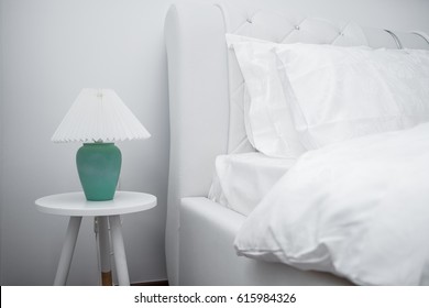 Bedside Table With Green Lamp Near White Clean And Modern Bedroom With Empty Wall 