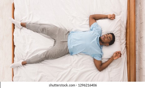 Bedtime. Black Millennial Guy Sleeping, Lying On Back In Bed, Top View