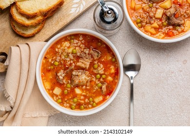 Beef Barley Soup With Vegetables, Potato, Green Peas, Carrot, Celery, Onion And Tomato. Bread. Directly Above.