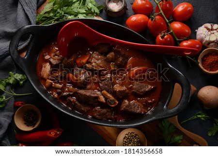 Beef Bourguignon in a pan. Stew with red wine ,carrots, onions, garlic, a bouquet garni, and garnished with pearl onions, mushrooms and bacon. French cuisine- regional recipe from Burgundy